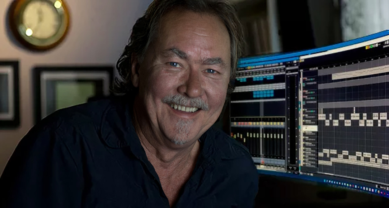 Jeff Watkinson at the desk in the YES AUDIO control room, smiling, multitrack session on the monitors behind him
